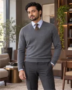 Man wearing a brown botanical-patterned tie and pale blue shirt under a grey V-neck sweater